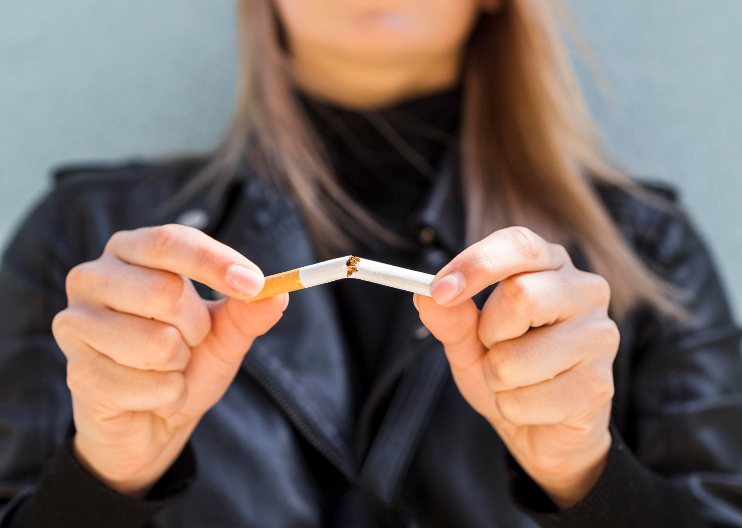 Mulher quebrando um cigarro ao meio
