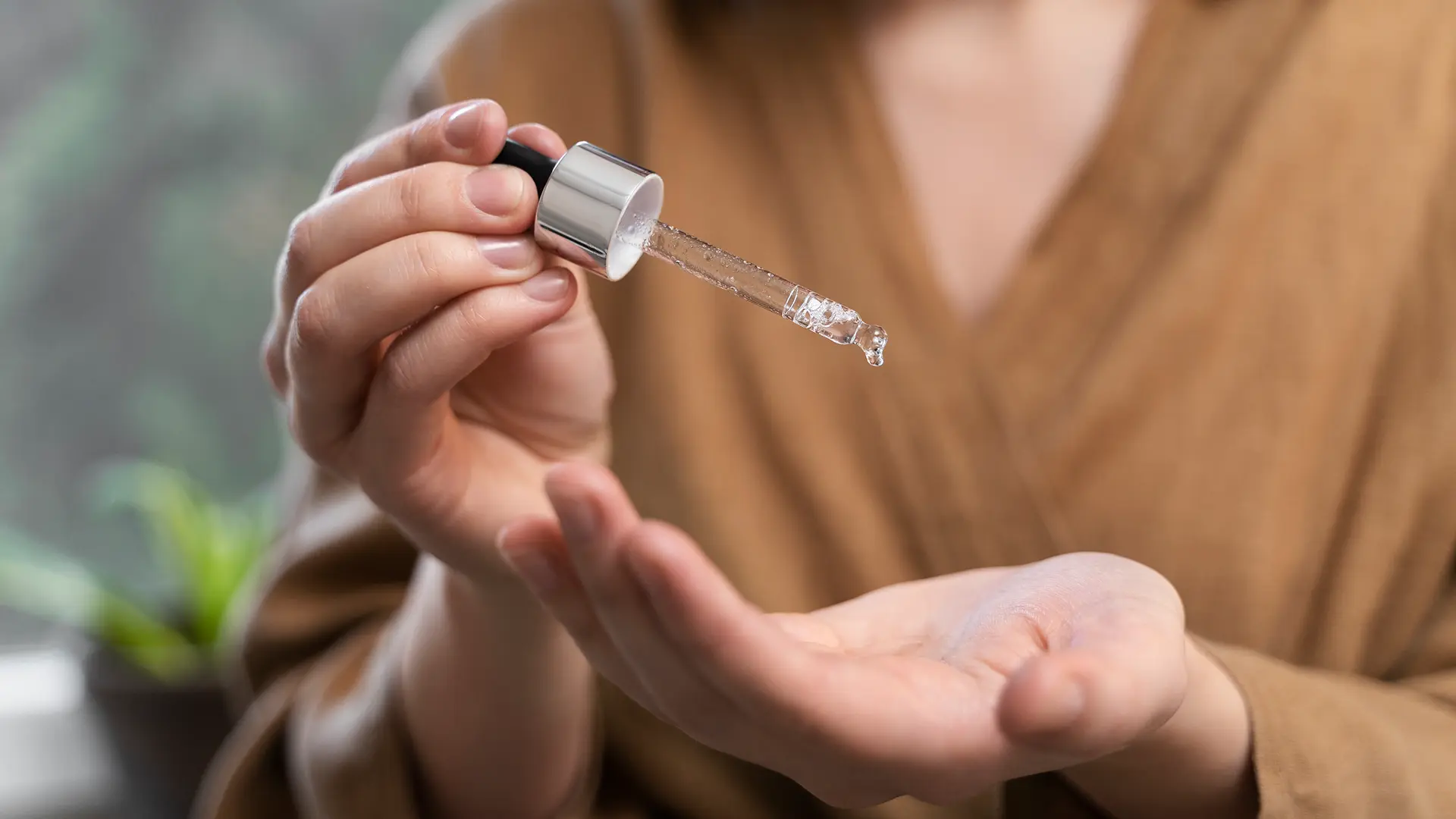 Mulher segura conta gotas com canabidiol