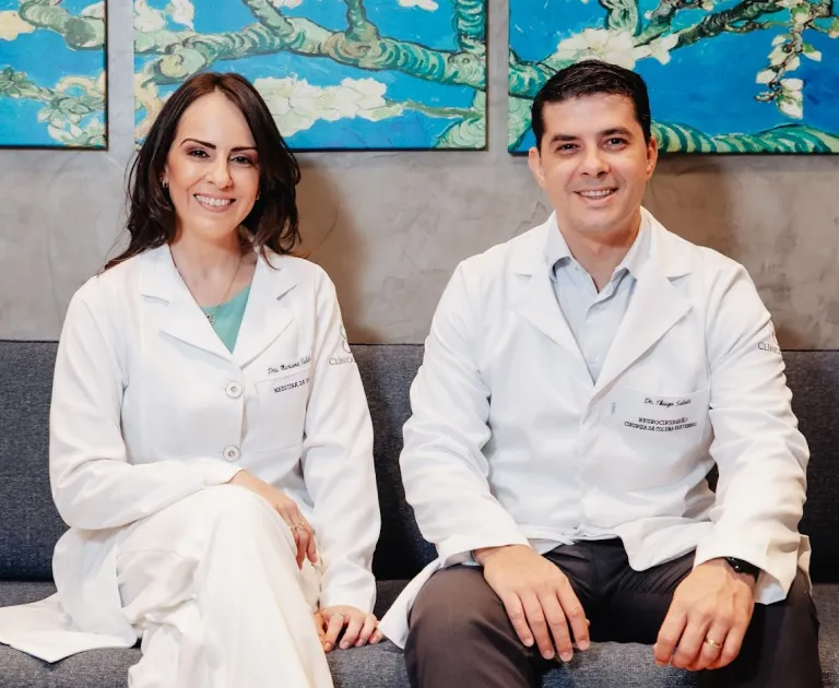 Dr. Thiago Salati e Dr. Mariane Salati sentados no sofá da clínica