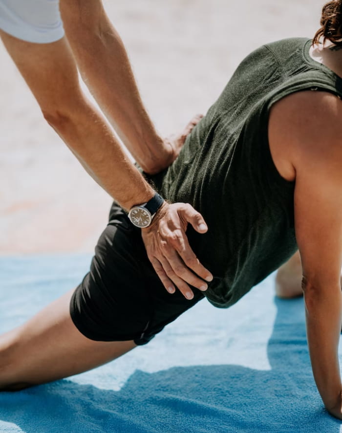 Fisioterapeuta auxilando homem em alongamento